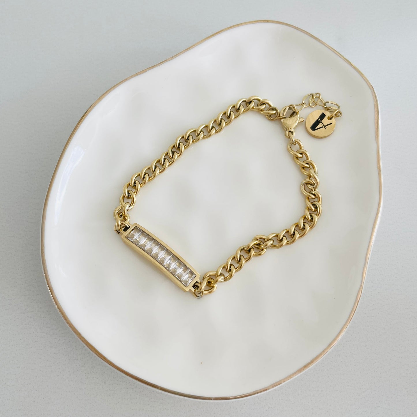 Pulsera Sasha dorada con zirconia exhibida sobre superficie blanca, joyería moderna de Vanytel