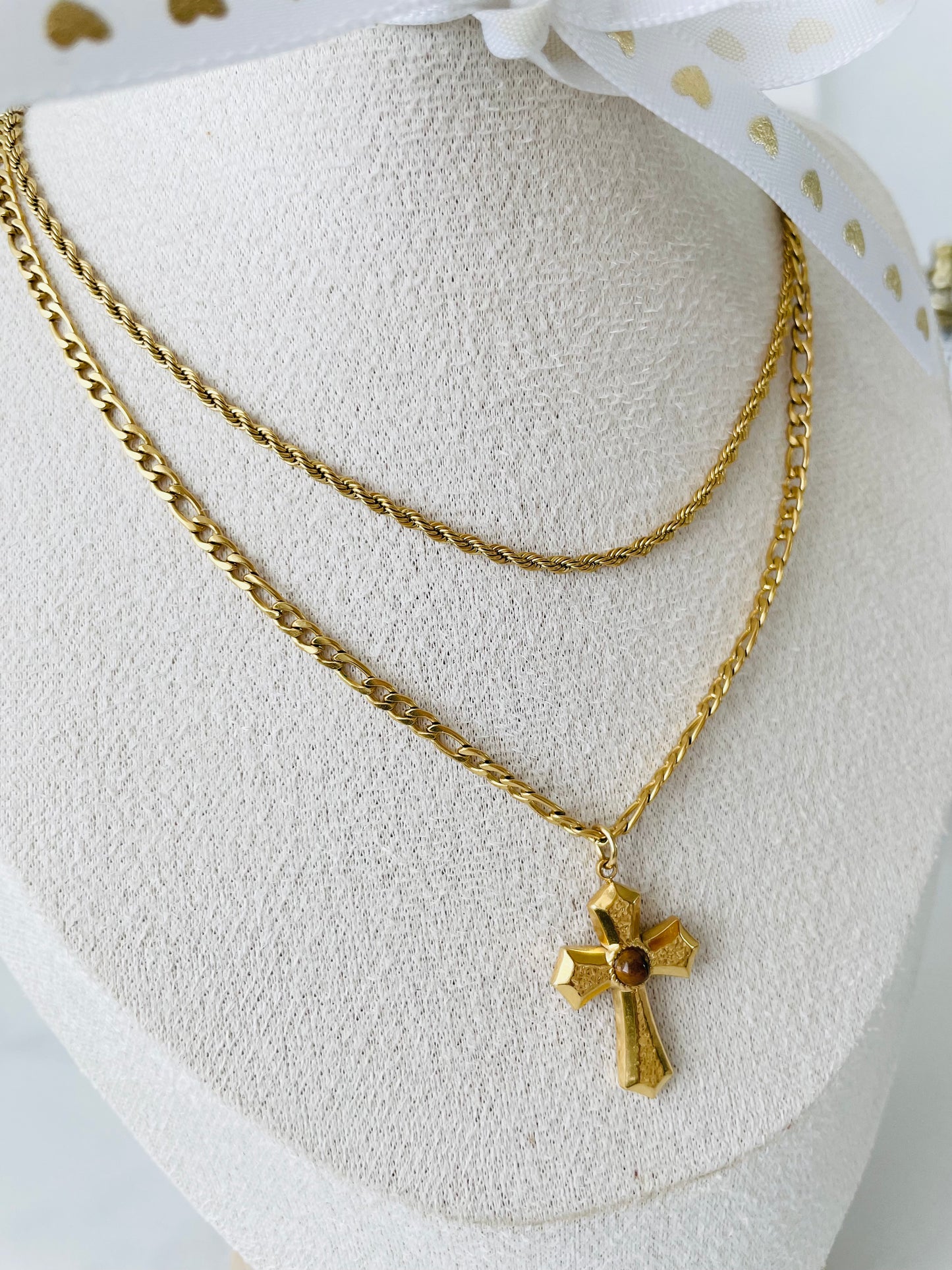 Modelo usando collar doble dorado con cruz, joyería Vanytel