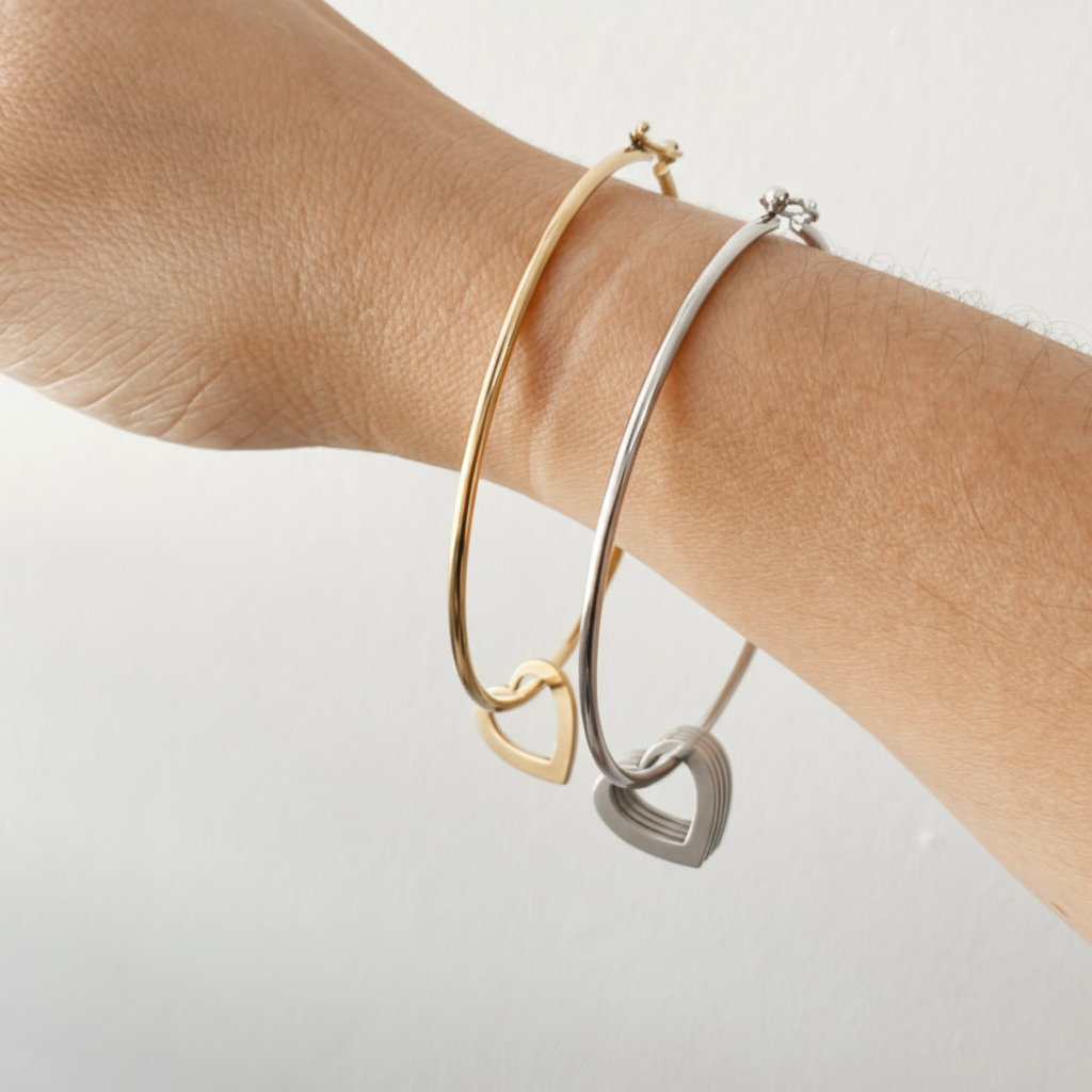 Detalle de la Pulsera Mis Amores Vanytel en mano mostrando los dijes de corazón dorados y plateados.
